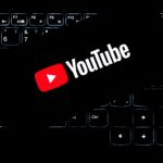 YouTube logo displayed on a backlit keyboard, representing digital media and online content creation.