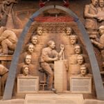 An elaborate relief sculpture depicting builders with a focus on historical figures and construction.
