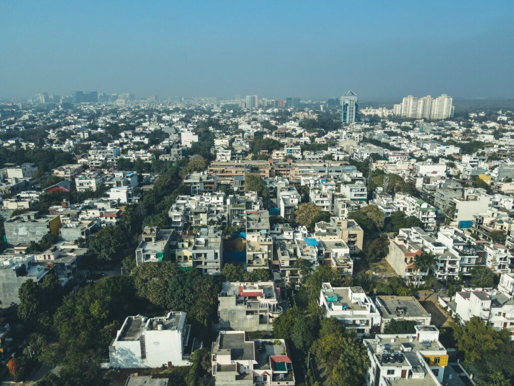 Aerial shot of Gurugram's urban landscape capturing dense residential buildings and city skyline.