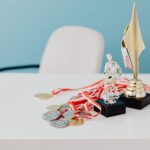 A collection of trophies and medals displayed on a white desk, symbolizing success and victory.