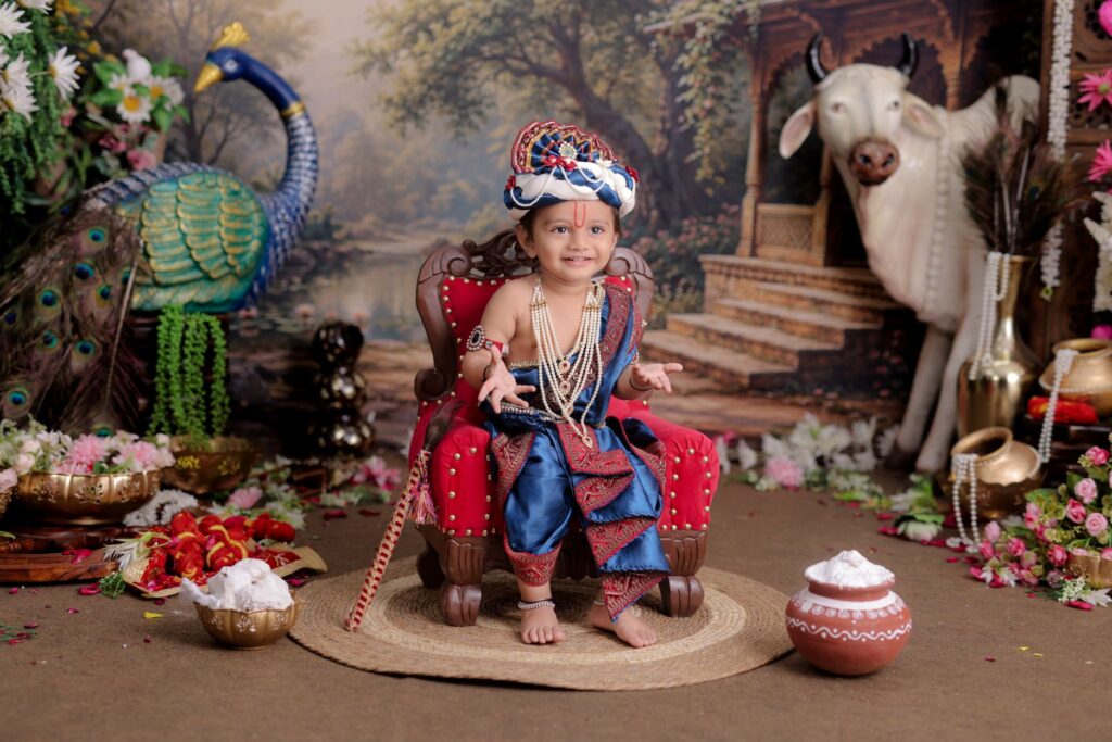 Adorable child dressed as Krishna, sitting with peacock and cow in a colorful setting.