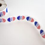 Close-up of a roll of 'I Voted' stickers featuring the American flag design on a white background.