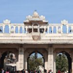 Crowds gather under the ornate gateway of Udaipur City Palace, a historic architectural gem.