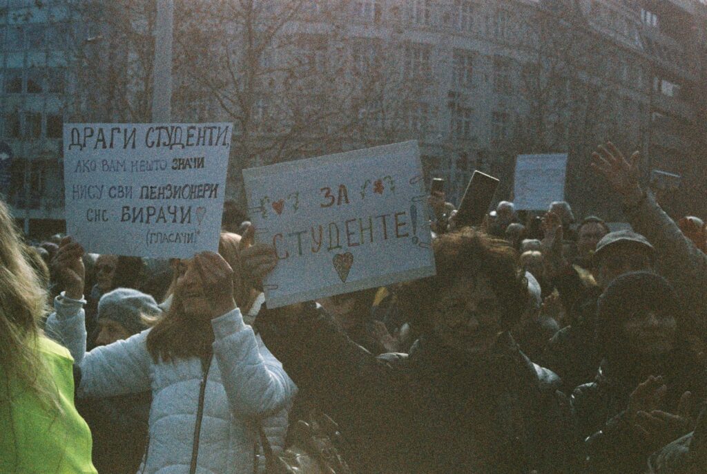 A large group of students holding signs during a peaceful protest outdoors.