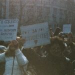 A large group of students holding signs during a peaceful protest outdoors.