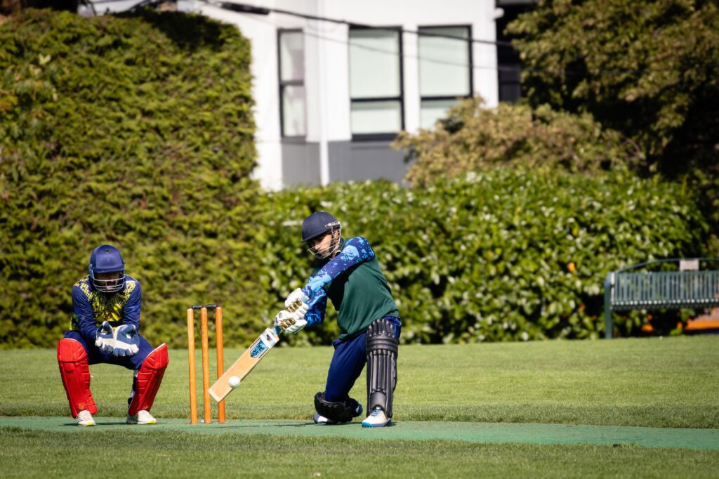 Dynamic cricket match scene with batsman in action, set outdoors in Victoria, Canada.