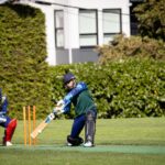 Dynamic cricket match scene with batsman in action, set outdoors in Victoria, Canada.