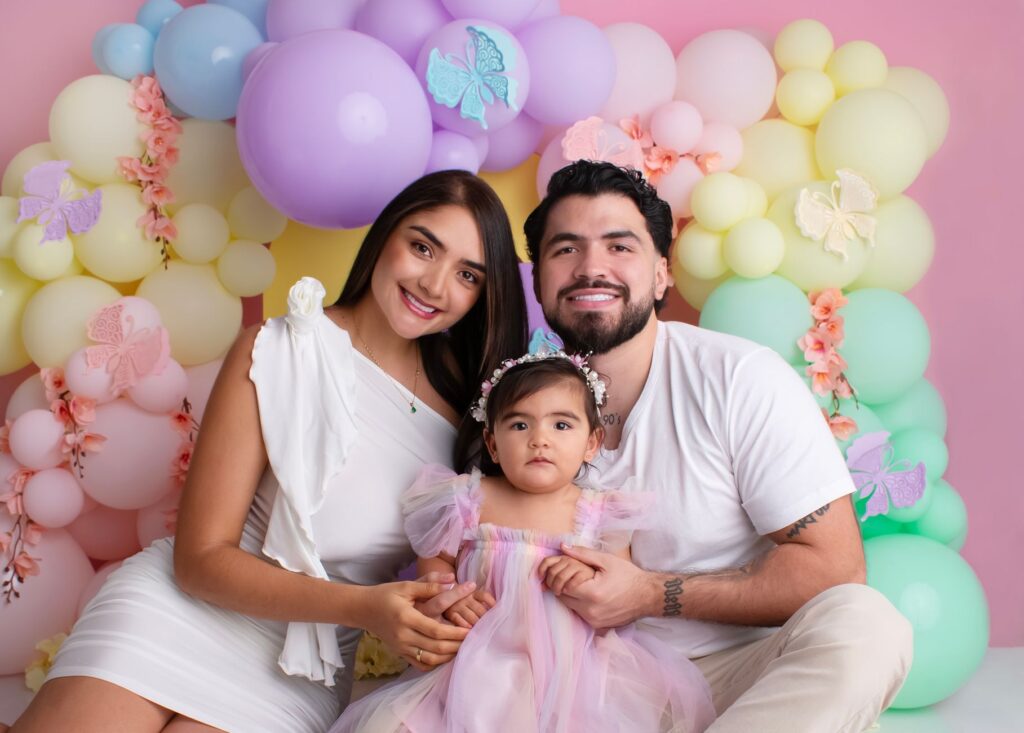 A joyful family posing in front of a vibrant balloon display, highlighting love and togetherness.