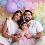 A joyful family posing in front of a vibrant balloon display, highlighting love and togetherness.