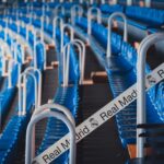 Rows of blue stadium seats in Madrid's iconic Bernabéu Stadium, featuring Real Madrid branding.