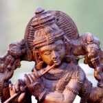 Close-up of a detailed wooden carving depicting a Hindu deity, highlighting artistic craftsmanship.