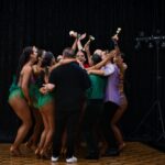 A dance team celebrates their victory with trophies and joy in Sydney, Australia.