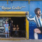 Vibrant storefront in La Boca featuring murals of football legends Maradona and Messi.