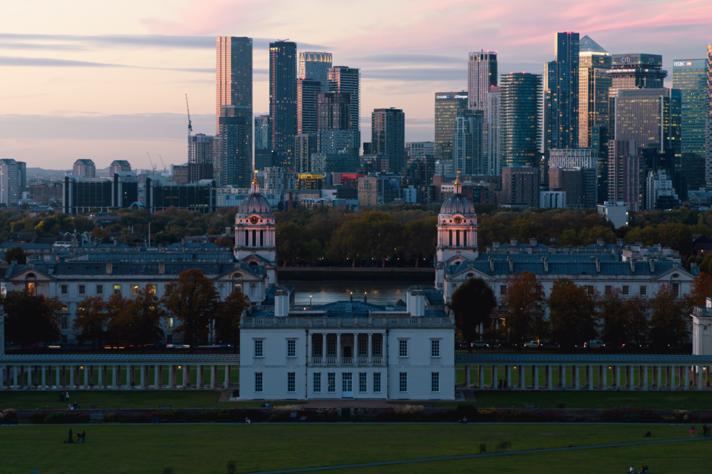 Capture the serene beauty of London's skyline at sunset with the historic Old Royal Naval College in the foreground.