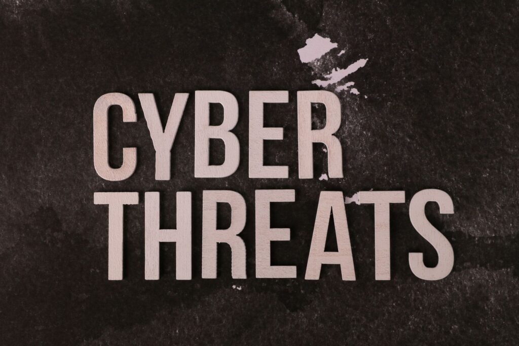 The phrase 'Cyber Threats' displayed on a textured dark background, emphasizing digital security.