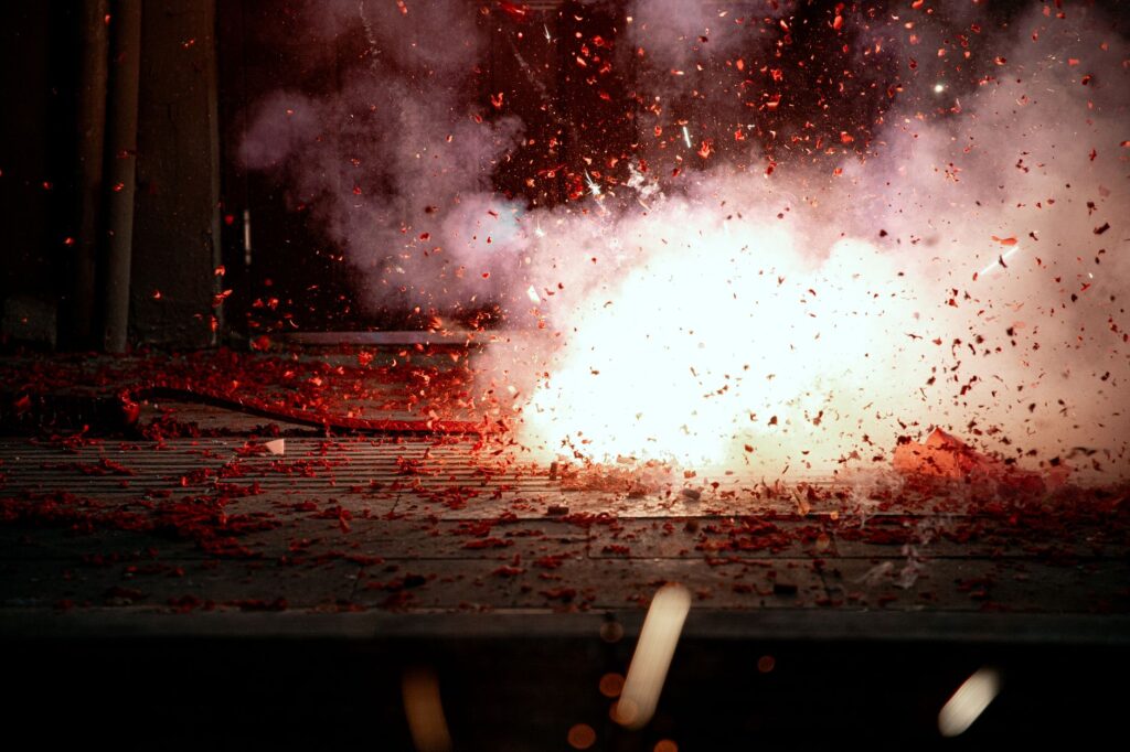 A mesmerizing explosion of firecrackers with vibrant red sparks lighting the scene.