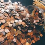 Spilled jar of pennies creating a pattern of coins representing savings and finance.