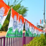 Congress party flags hanging on a roadside railing in Mangaluru, India, symbolizing political promotion.