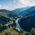 A breathtaking view of a river winding through the lush green valleys of Kalimpong in the Himalayas.