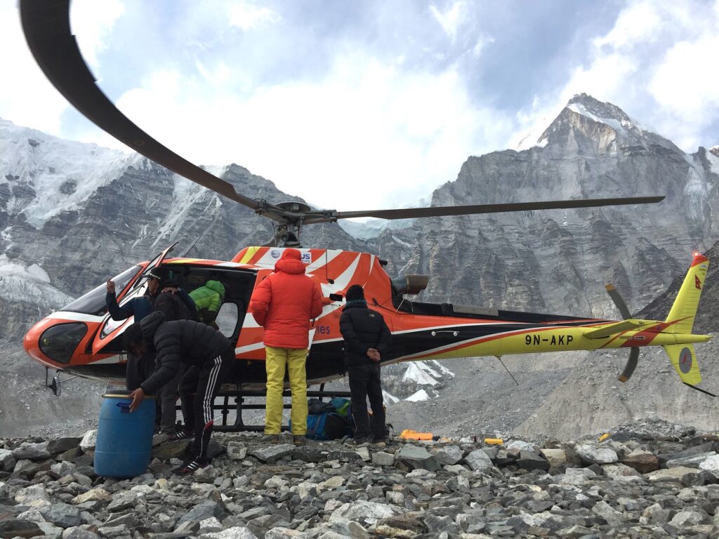 A helicopter and climbers at a high-altitude Himalayas location, Nepal.