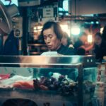 A bustling Korean food market stall in Seoul, featuring fresh seafood and a vibrant atmosphere.
