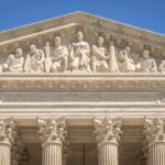 Detailed view of the Supreme Court Building's frontal frieze depicting historical figures and justices.