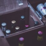 Close-up of various alcohol bottles and cans in cardboard boxes indoors.