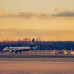 A Ryanair plane at Wrocław Airport at sunset with warm lighting and clear skies.