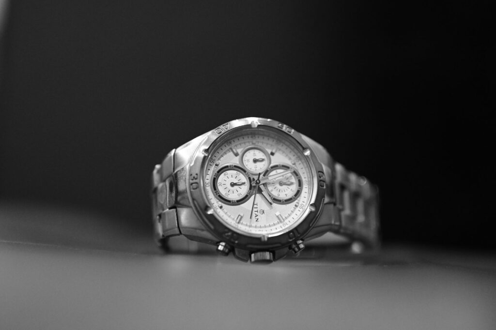 Sophisticated black and white macro shot of a luxury silver wristwatch showcasing precision details.