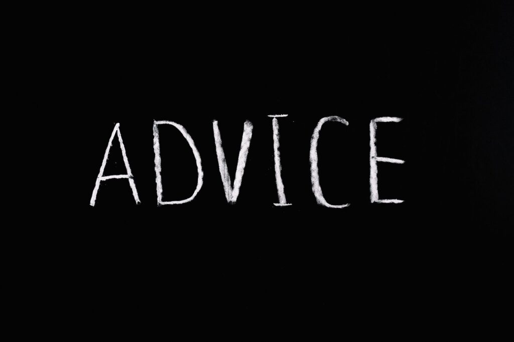 Inspirational word 'Advice' written in white chalk on blackboard.