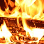 Captivating close-up of a log burning with vivid yellow and orange flames. Ideal for fire-themed visuals.