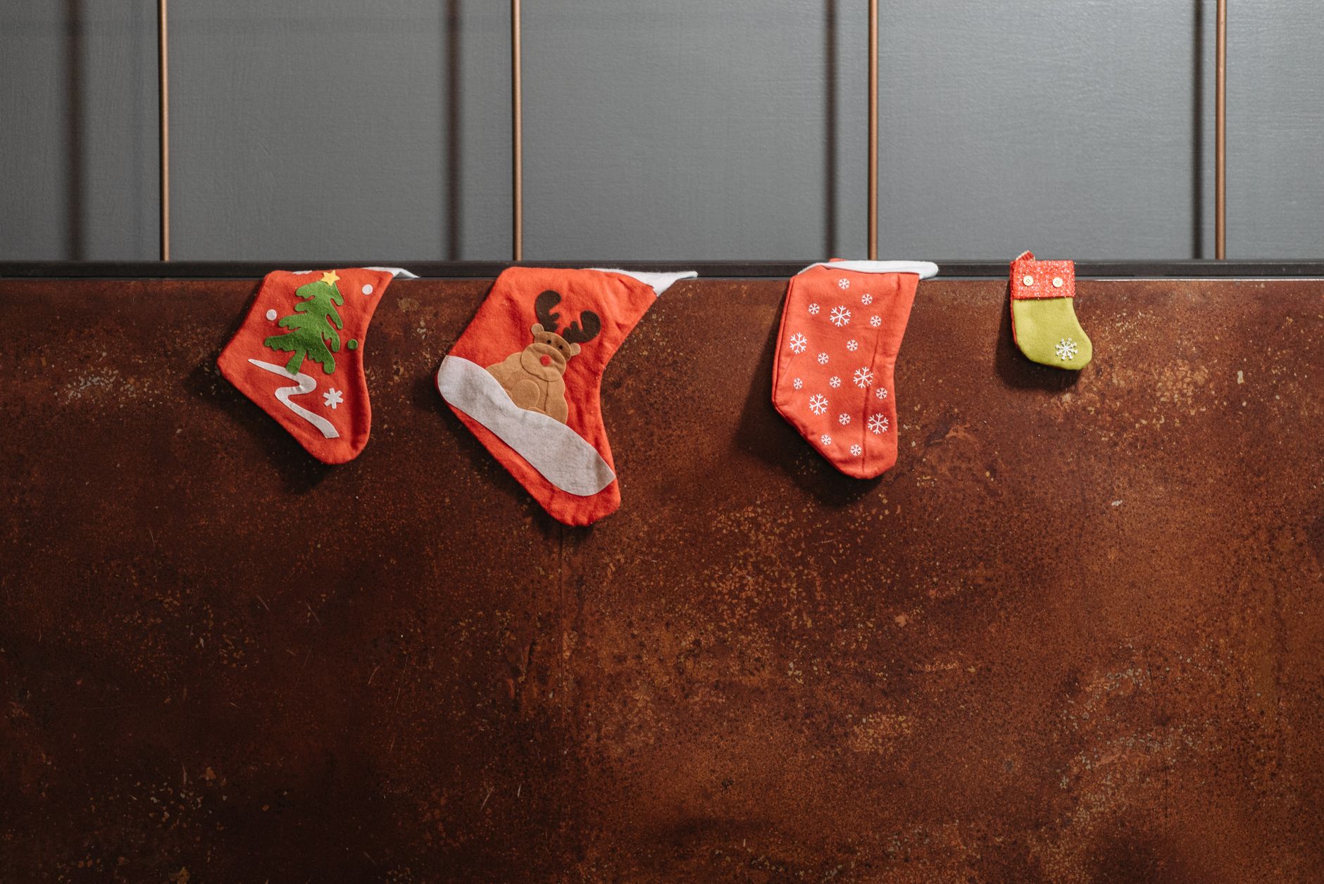Four decorative Christmas stockings hanging indoors with festive patterns. Perfect for holiday decor inspiration.