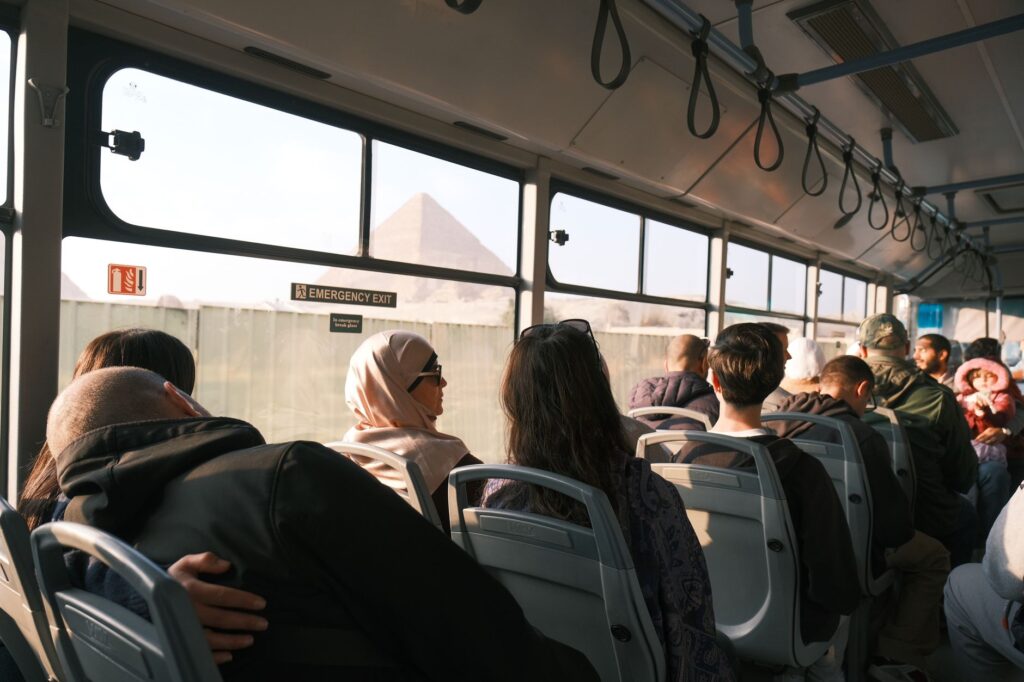 Passengers on a bus with a view of the Pyramid, capturing a moment in Cairo, Egypt.