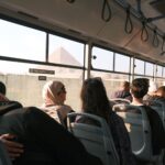 Passengers on a bus with a view of the Pyramid, capturing a moment in Cairo, Egypt.