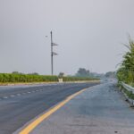 Serene landscape of an empty expressway in Deeg, India with lush greenery.