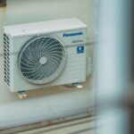 Air conditioner unit mounted outdoors on a building wall, showcasing modern HVAC technology.