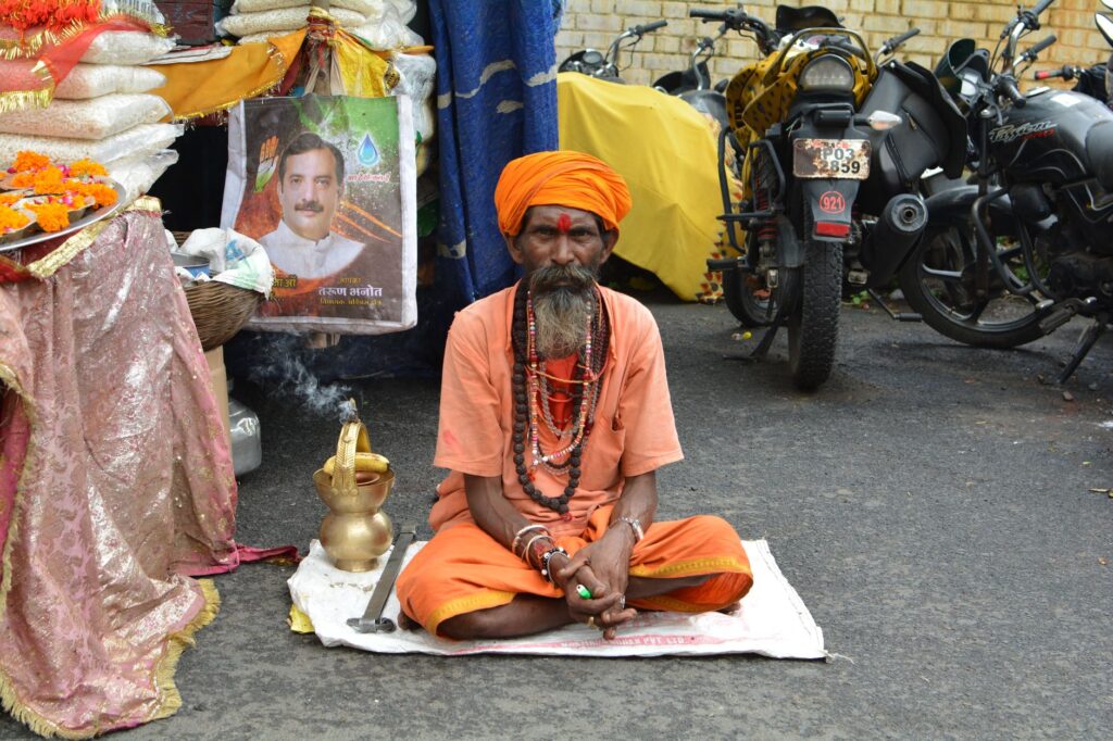 An Indian Sadhu in traditional attire meditates on a street in Jabalpur, India.