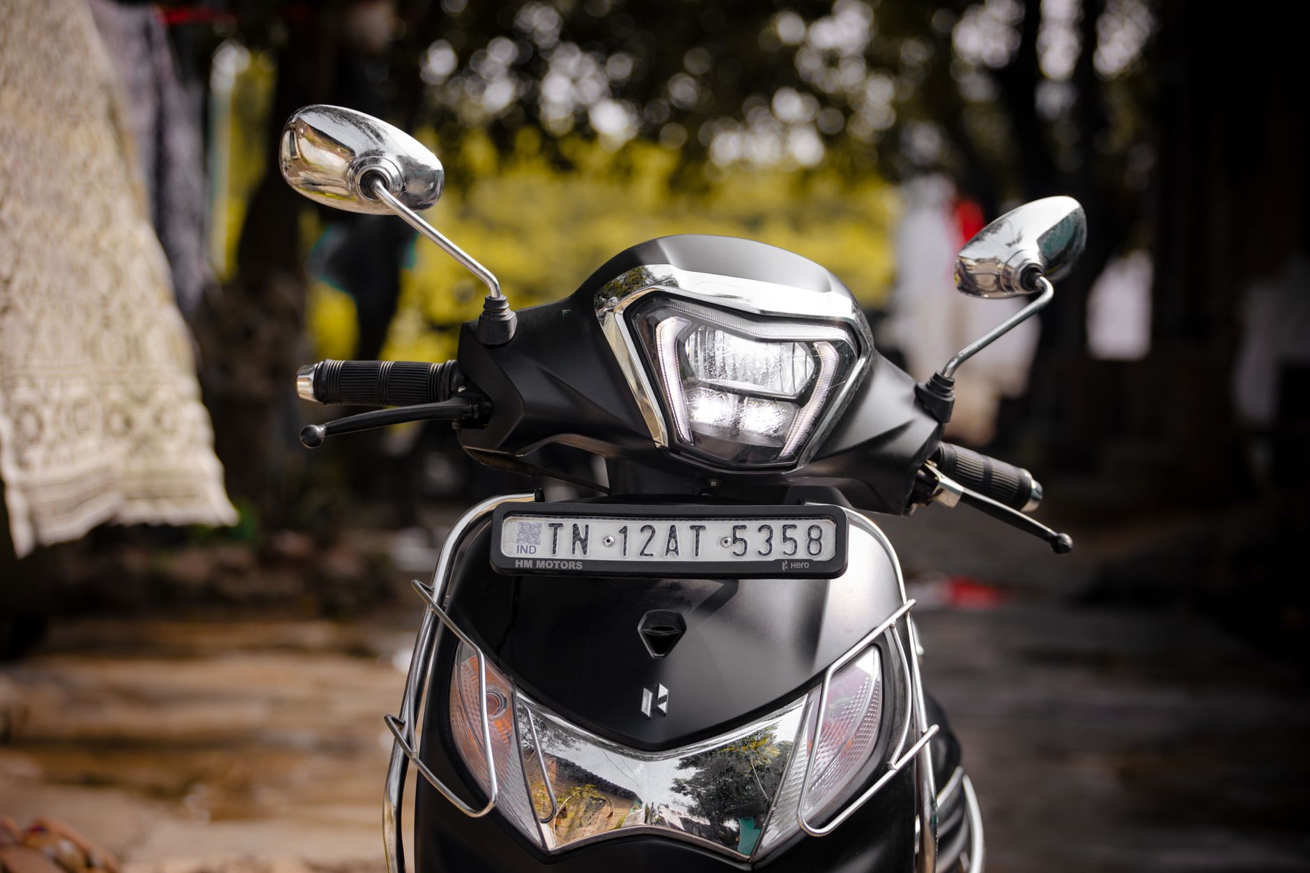 Front view of a black motorbike parked on a street in Chennai, India.