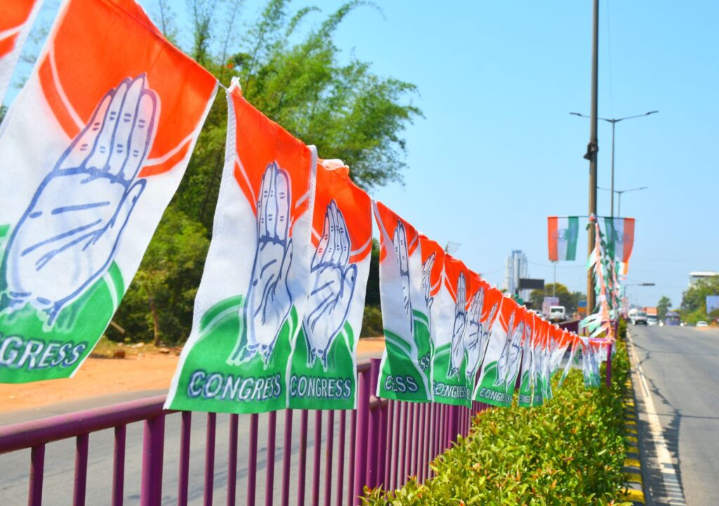Congress party flags hanging on a roadside railing in Mangaluru, India, symbolizing political promotion.