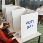 People casting votes in a polling station on election day, emphasizing civic engagement.