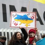 Demonstrators rally for Ukraine in Vancouver, holding signs and flags during a peaceful protest.