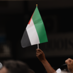 Close-up of a hand holding a Palestinian flag during protest in Rabat, Morocco.