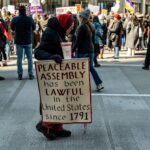 A demonstration advocating peaceable assembly rights in a city street.