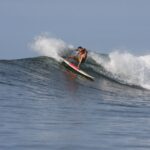 Captivating action shot of a surfer riding the powerful waves of El Salvador's coast.