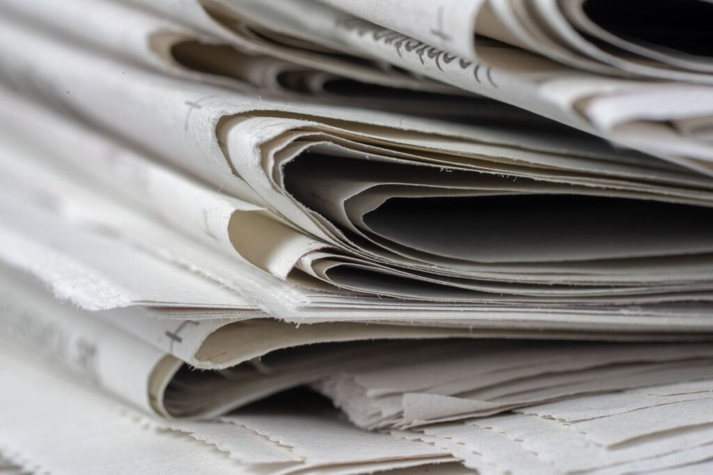 A detailed close-up view of stacked newspapers, highlighting textures and layers.