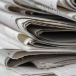 A detailed close-up view of stacked newspapers, highlighting textures and layers.