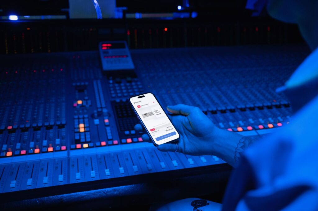 A smartphone displaying digital payment in a modern music studio setting.