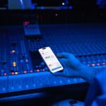 A smartphone displaying digital payment in a modern music studio setting.