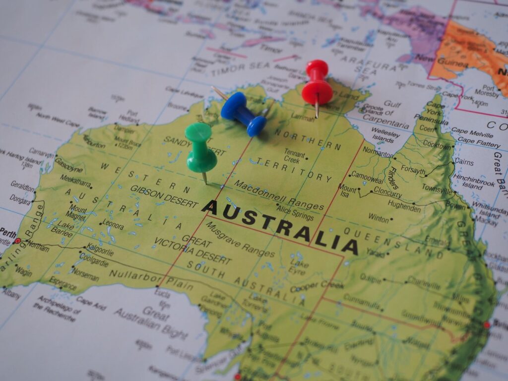 Close-up of a map of Australia featuring colorful pushpins marking locations.