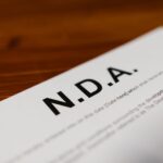 Focused close-up of an NDA document on a wooden desk, highlighting contract details.